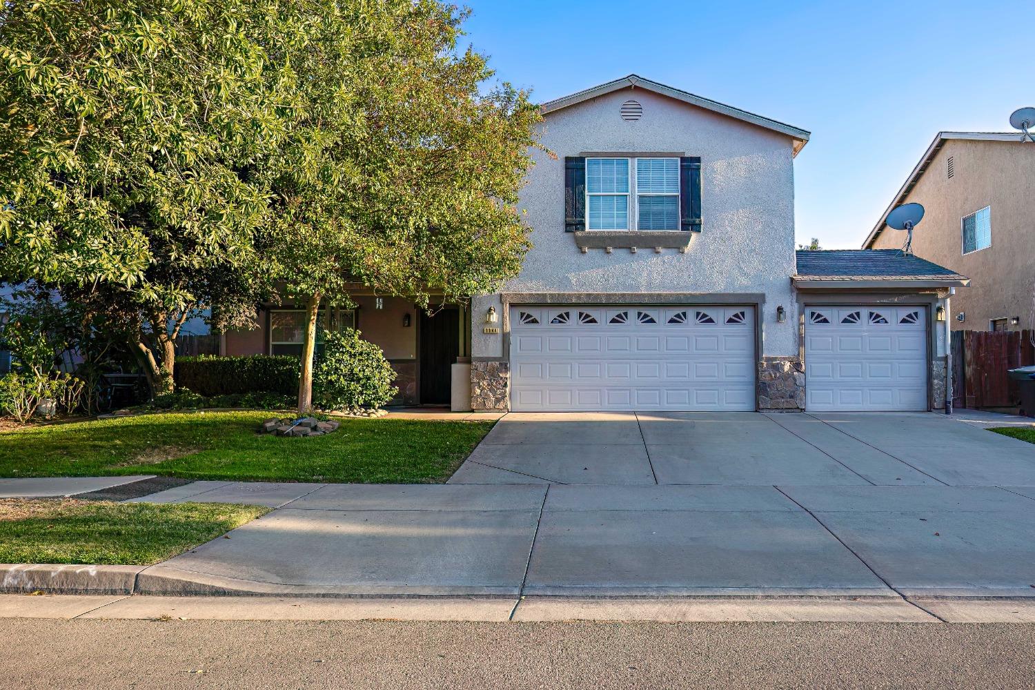 a front view of a house with a yard and a garage