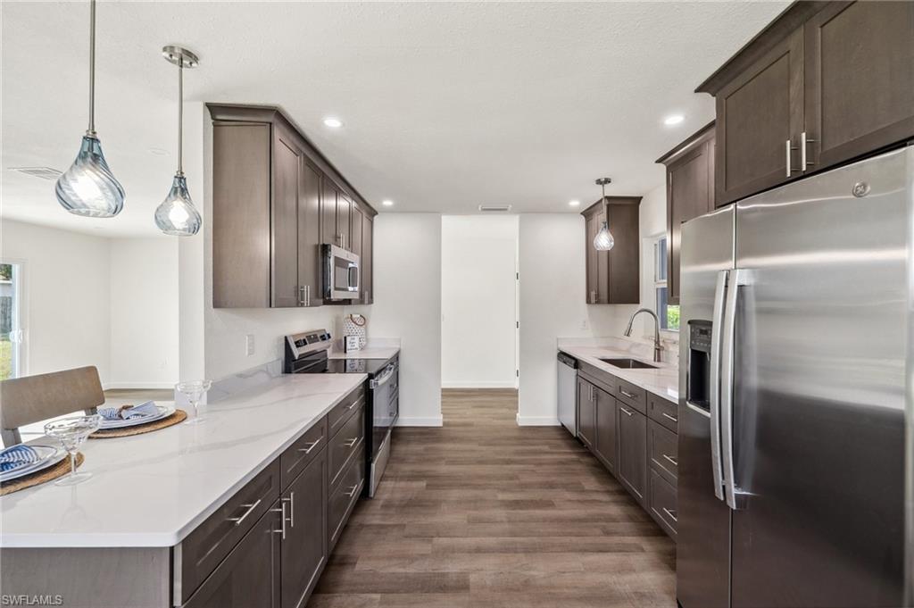 a large kitchen with stainless steel appliances granite countertop a lot of counter space and wooden floor