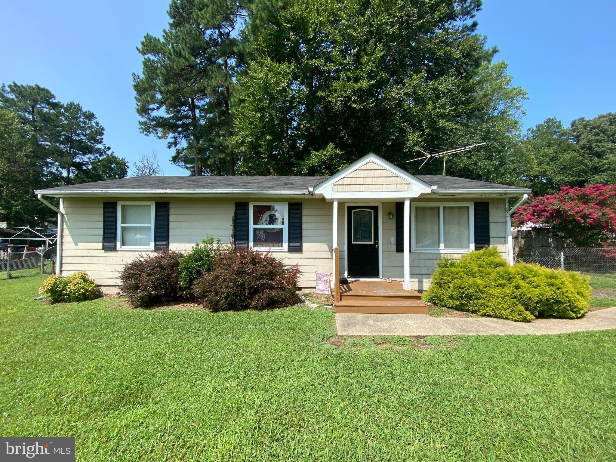 a front view of a house with a yard and green space