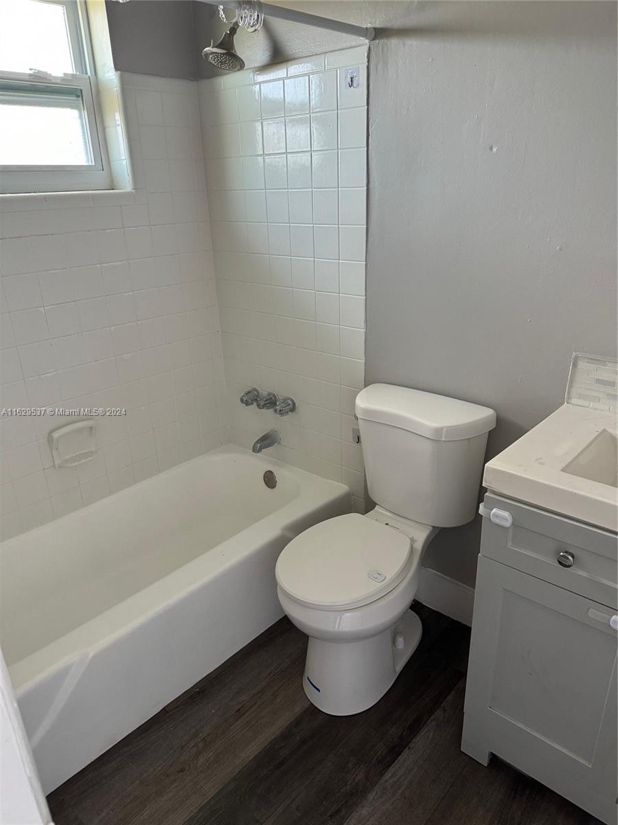 a white toilet sitting next to a bath tub