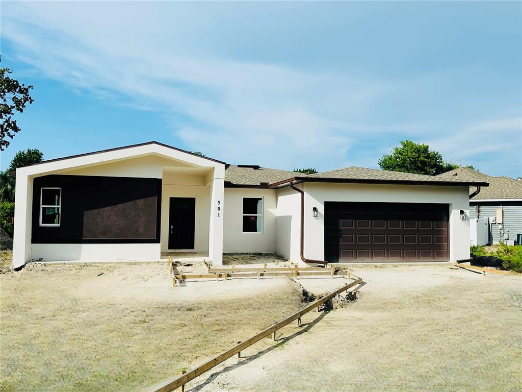 a view of a house with yard and garage