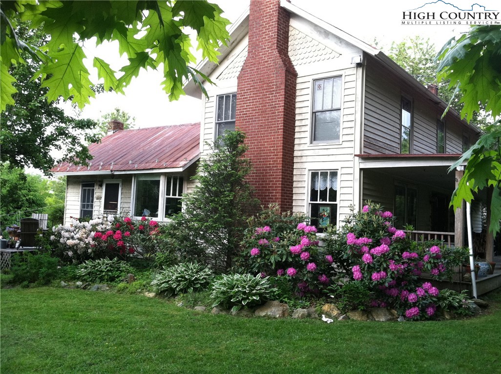 a view of a house with a yard and potted plants