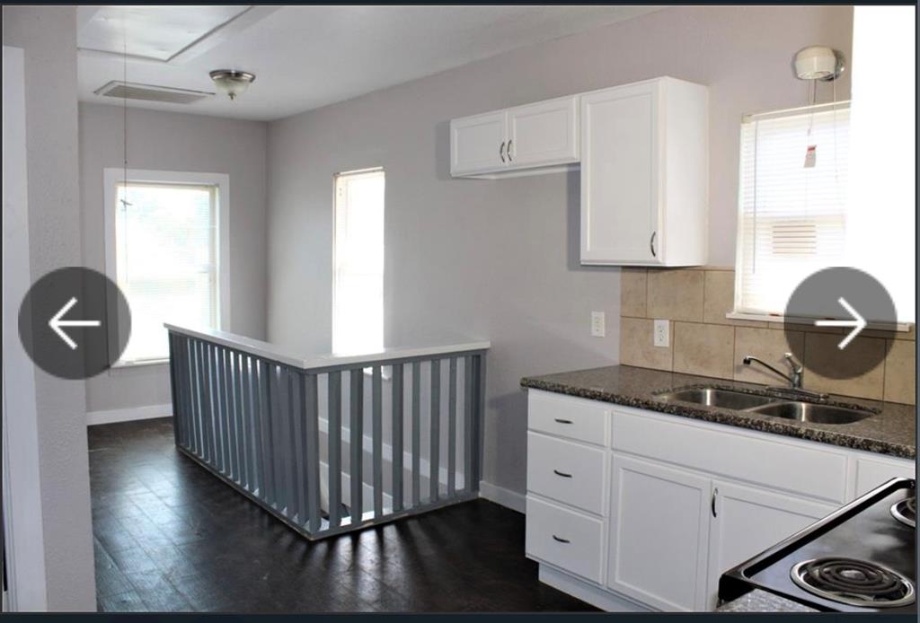 a kitchen with wooden cabinets a stove and a window