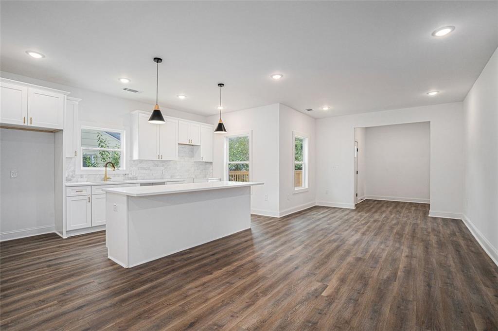 a large kitchen with kitchen island white cabinets and wooden floor