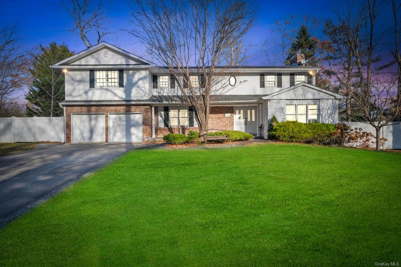 View of front of house with a lawn and a garage