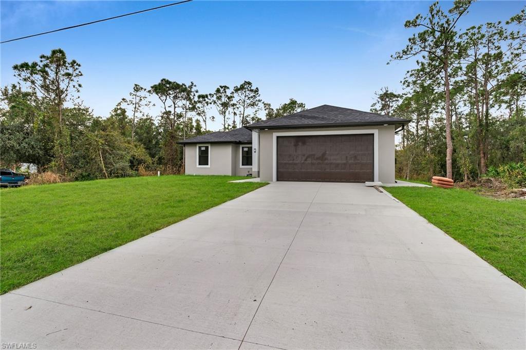 a front view of a house with a yard and trees