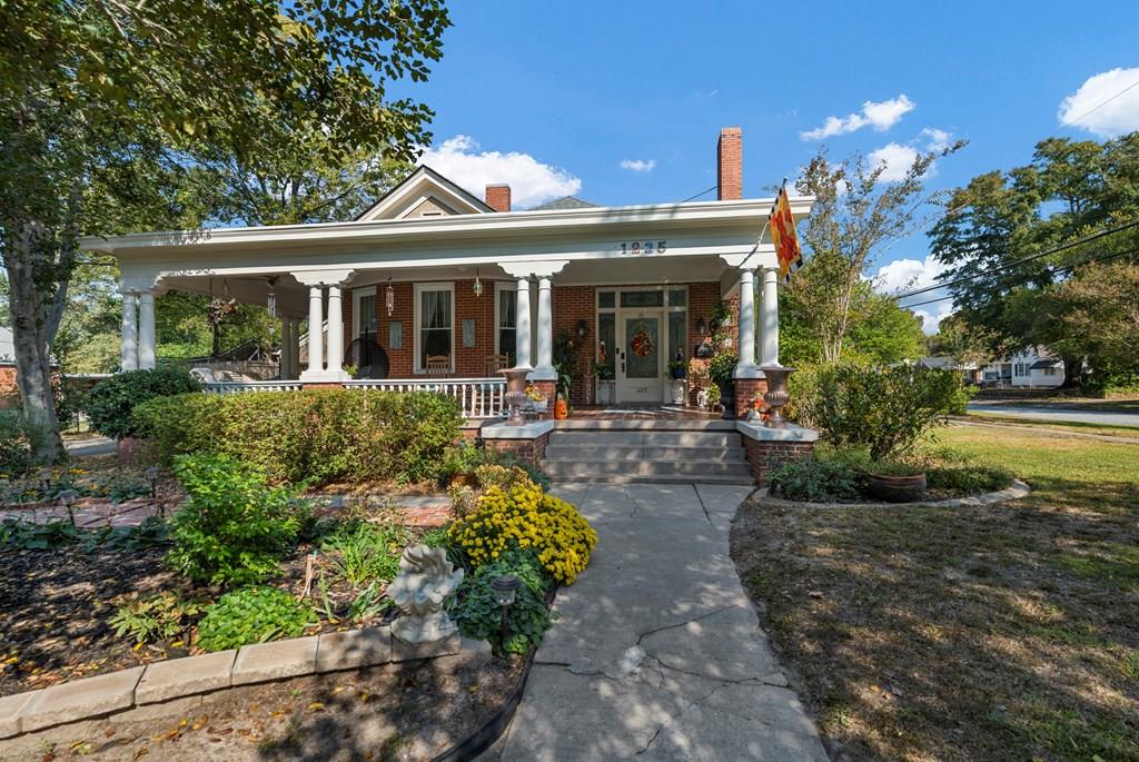 a front view of a house with a yard and green space