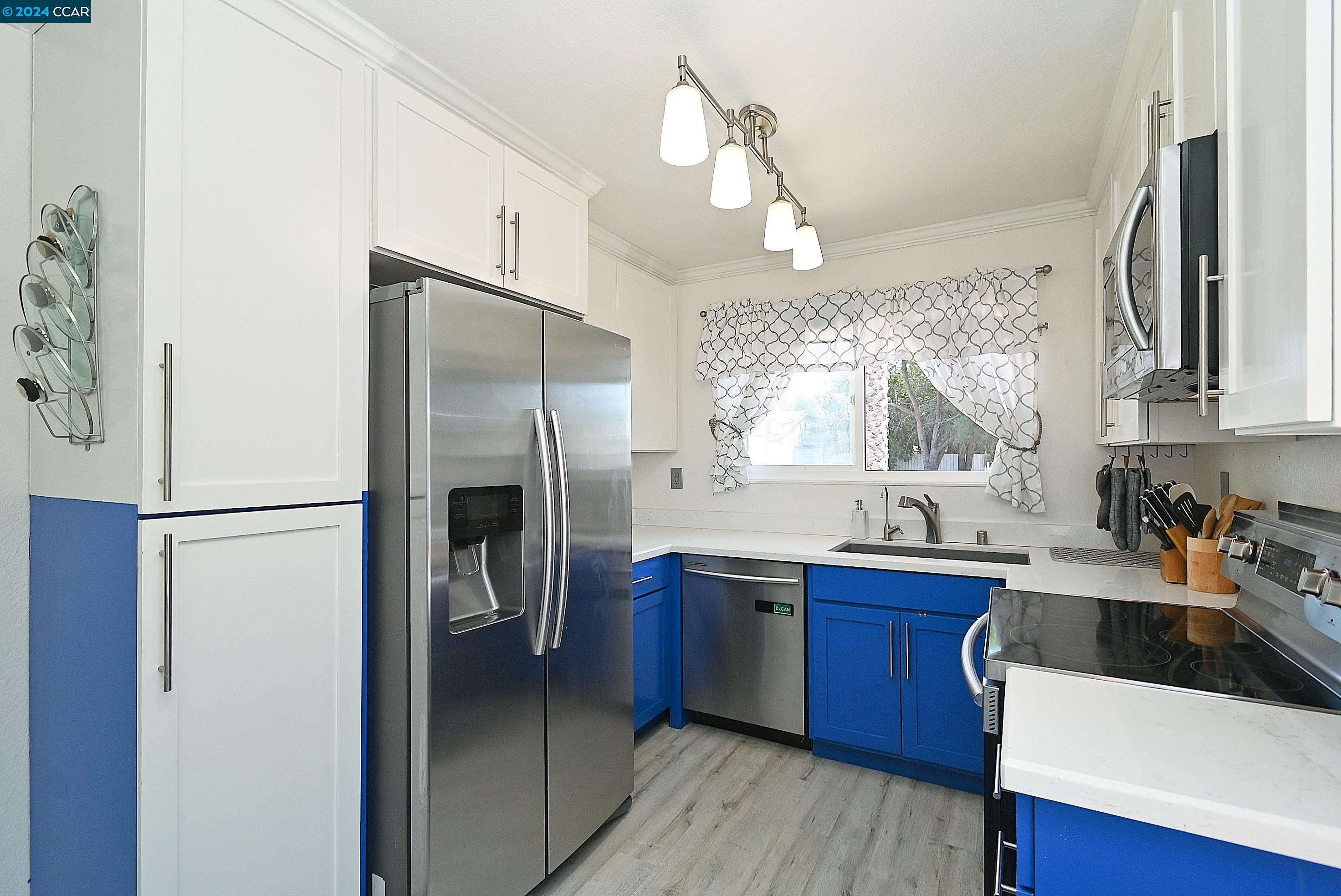 a kitchen with stainless steel appliances a refrigerator sink and cabinets