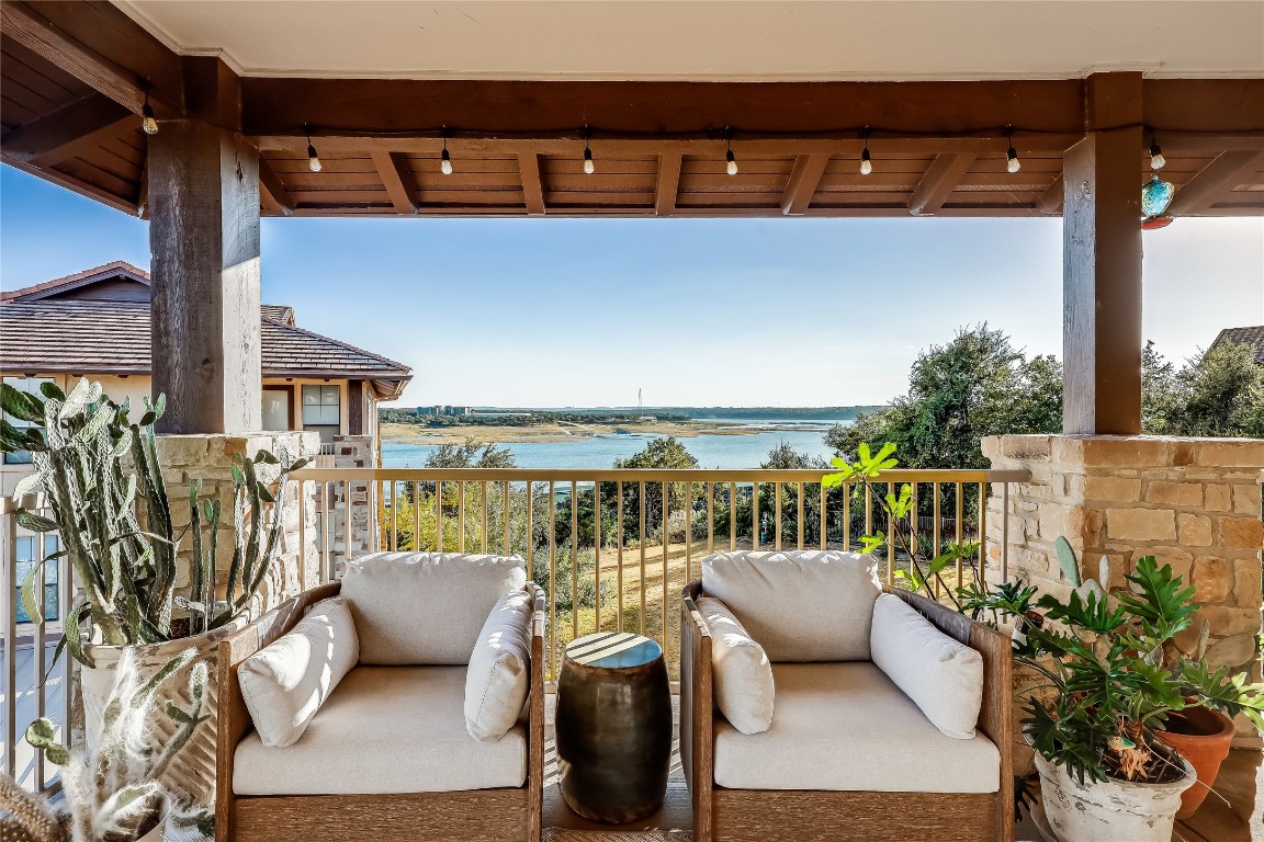 a view of a balcony with couch and chairs