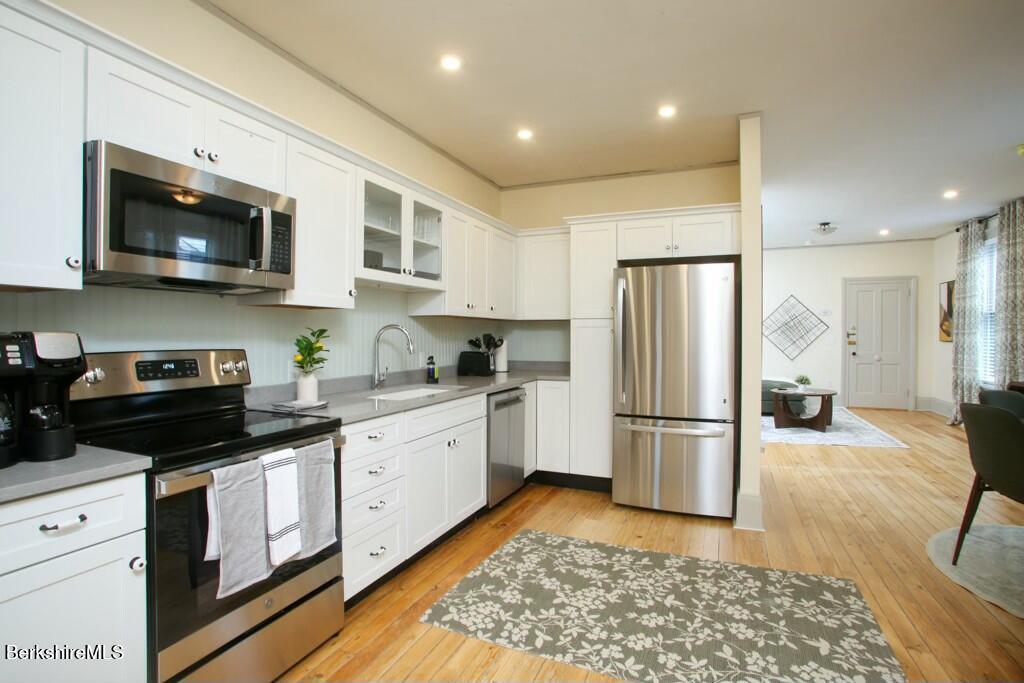 a kitchen with stainless steel appliances granite countertop a refrigerator a stove top oven a sink and dishwasher