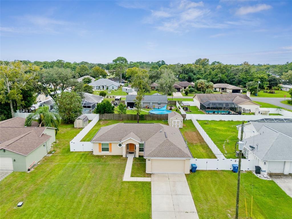 an aerial view of residential houses with outdoor space and a swimming pool