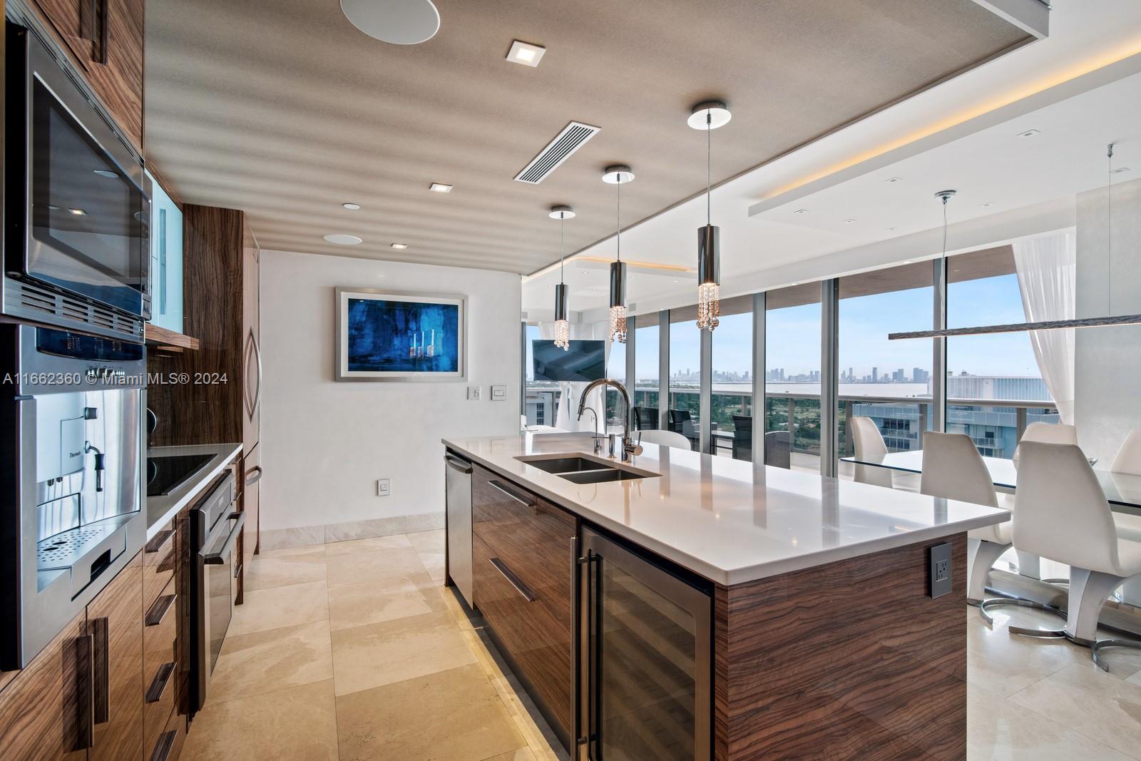 a kitchen with stainless steel appliances granite countertop a lot of counter space and a large window