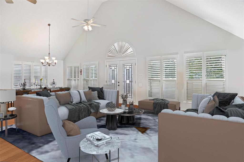 a living room with furniture a large window and a chandelier