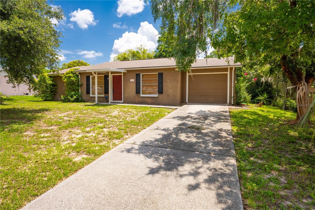 a front view of a house with a yard and trees