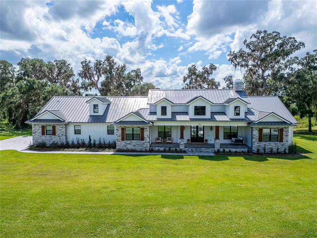 a view of a large house with a big yard and large trees