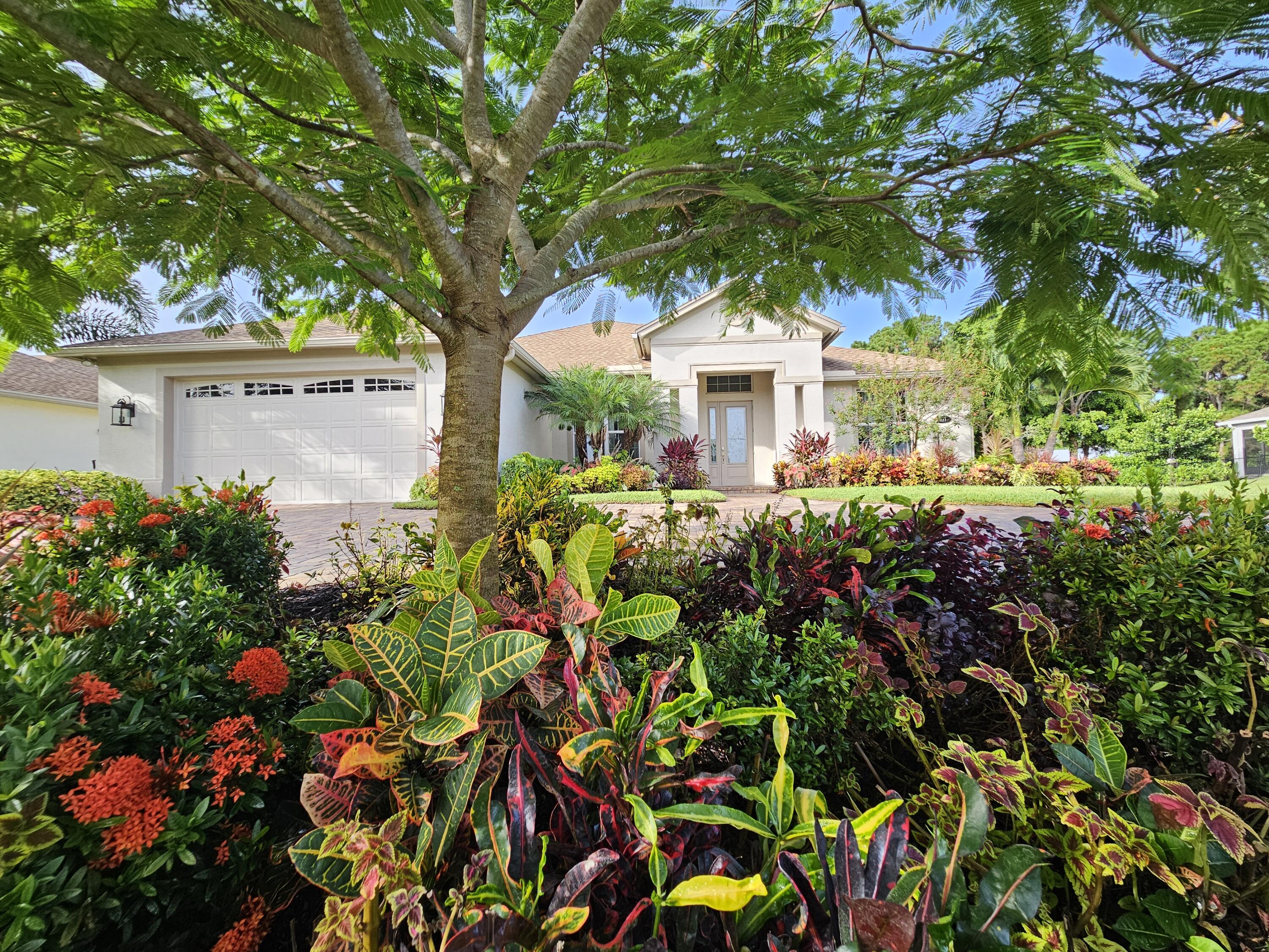 a front view of a house with a flower garden