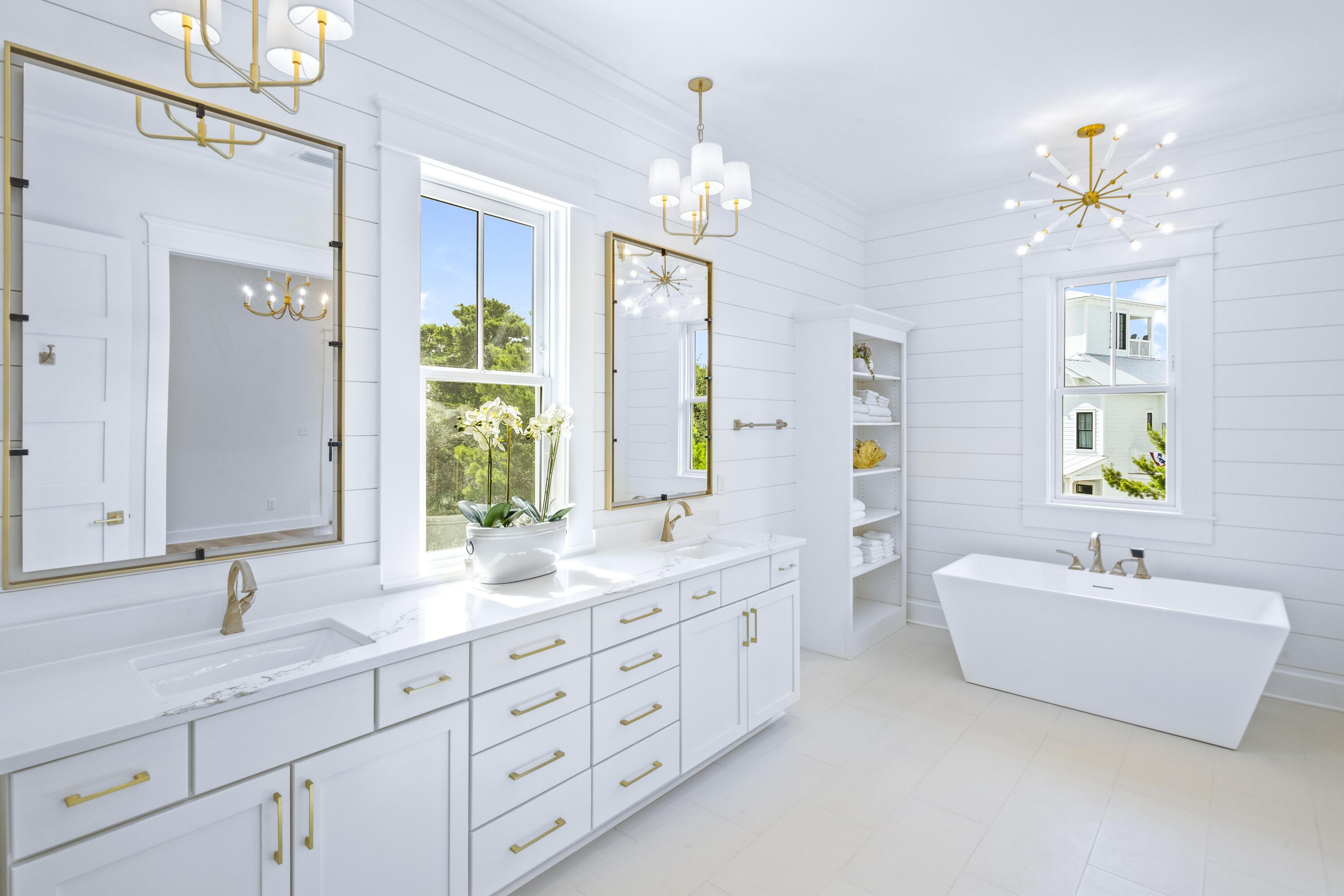 a bathroom with double vanity sinks a vanity a lamp and a shower