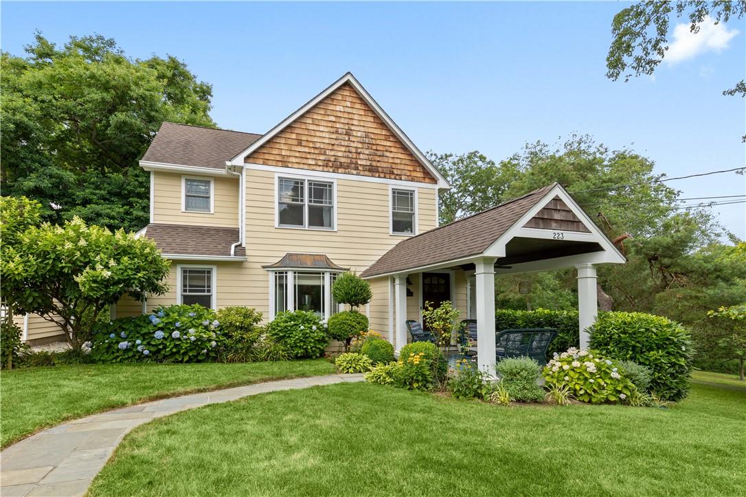 a front view of a house with a yard and trees