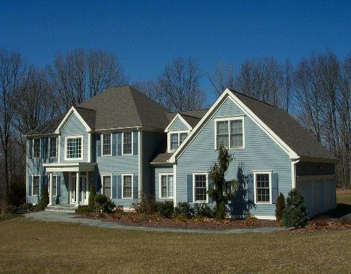 a front view of house with yard and trees in the background