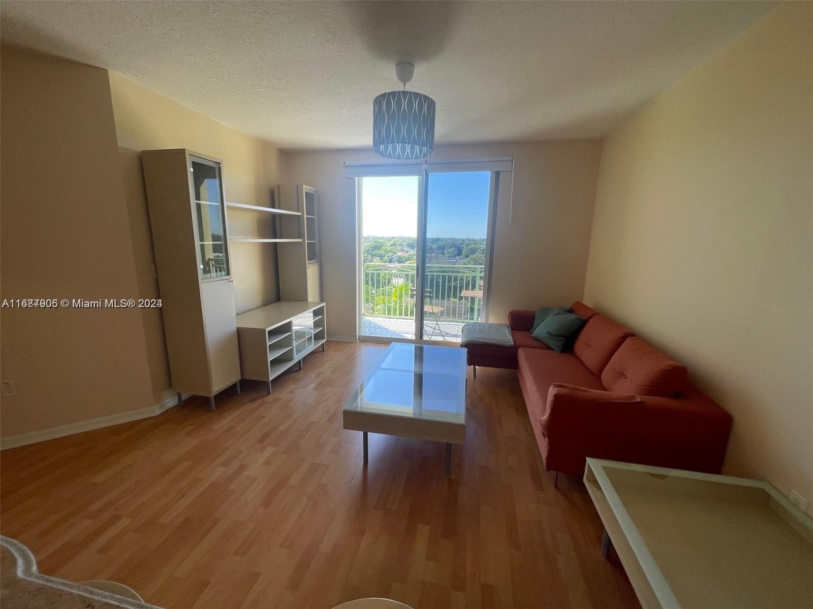 a living room with furniture window and wooden floor