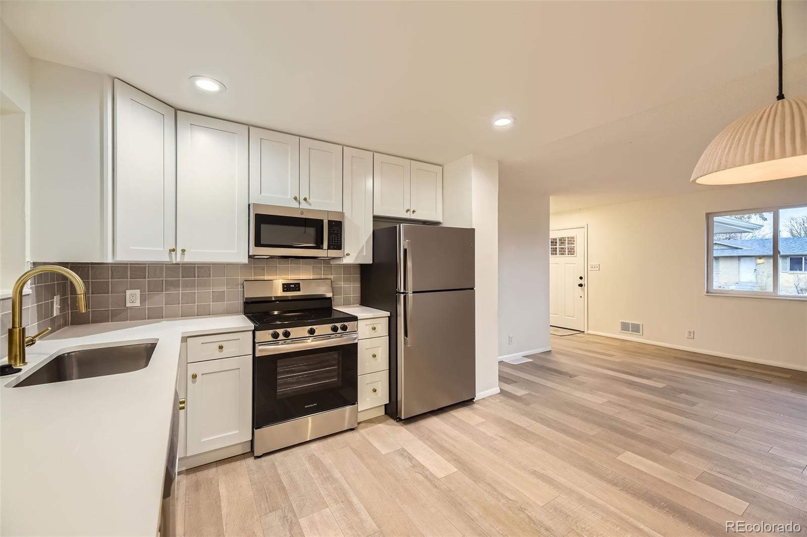 a kitchen with granite countertop a sink stainless steel appliances and cabinets