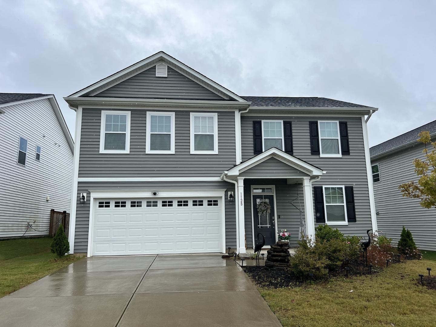 a front view of a house with yard and garage