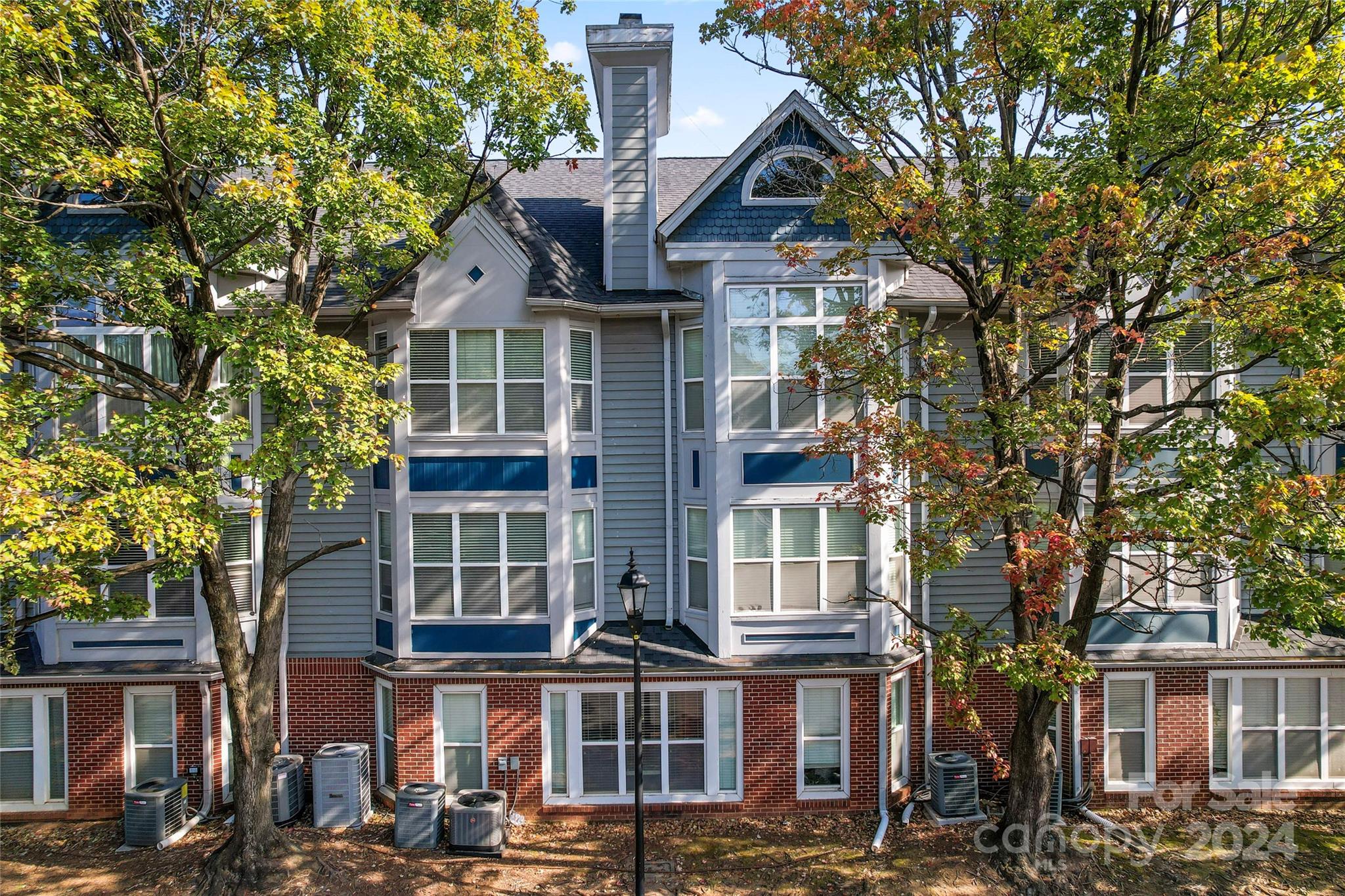 a front view of a residential apartment building with a yard