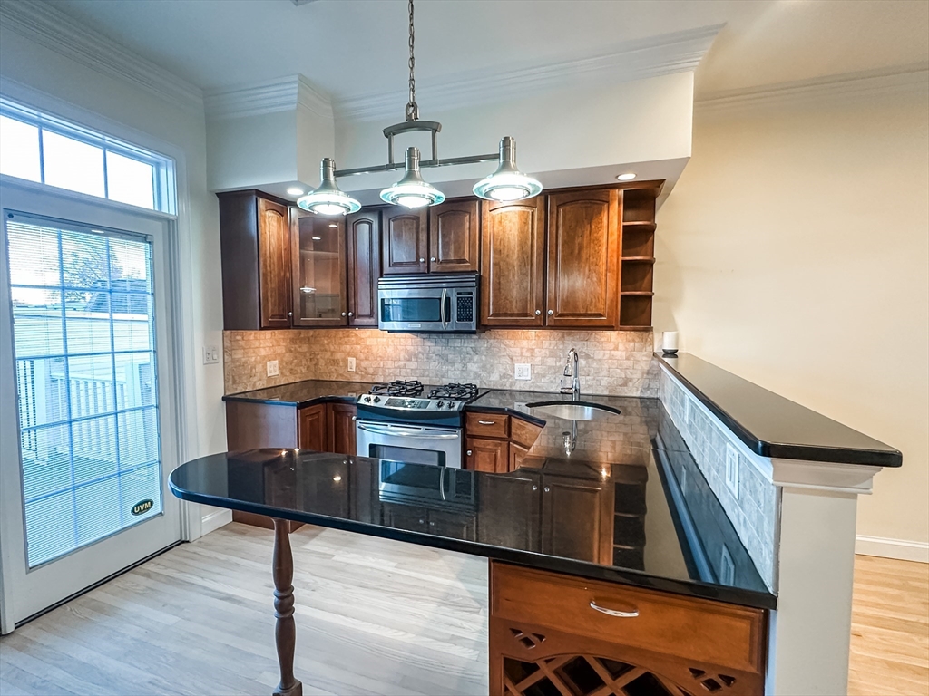 a kitchen with stainless steel appliances granite countertop a stove a sink and a microwave