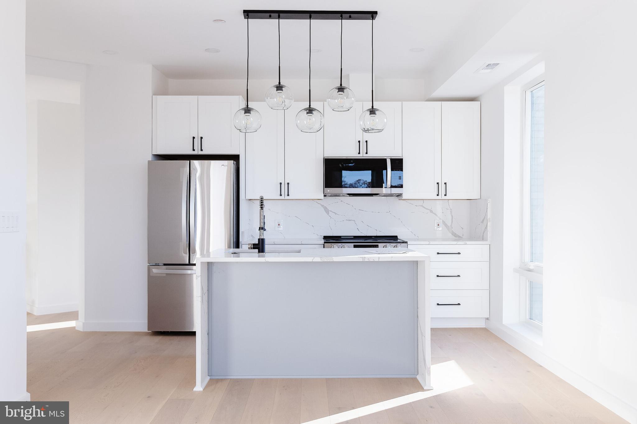 a kitchen with stainless steel appliances a refrigerator sink and cabinets