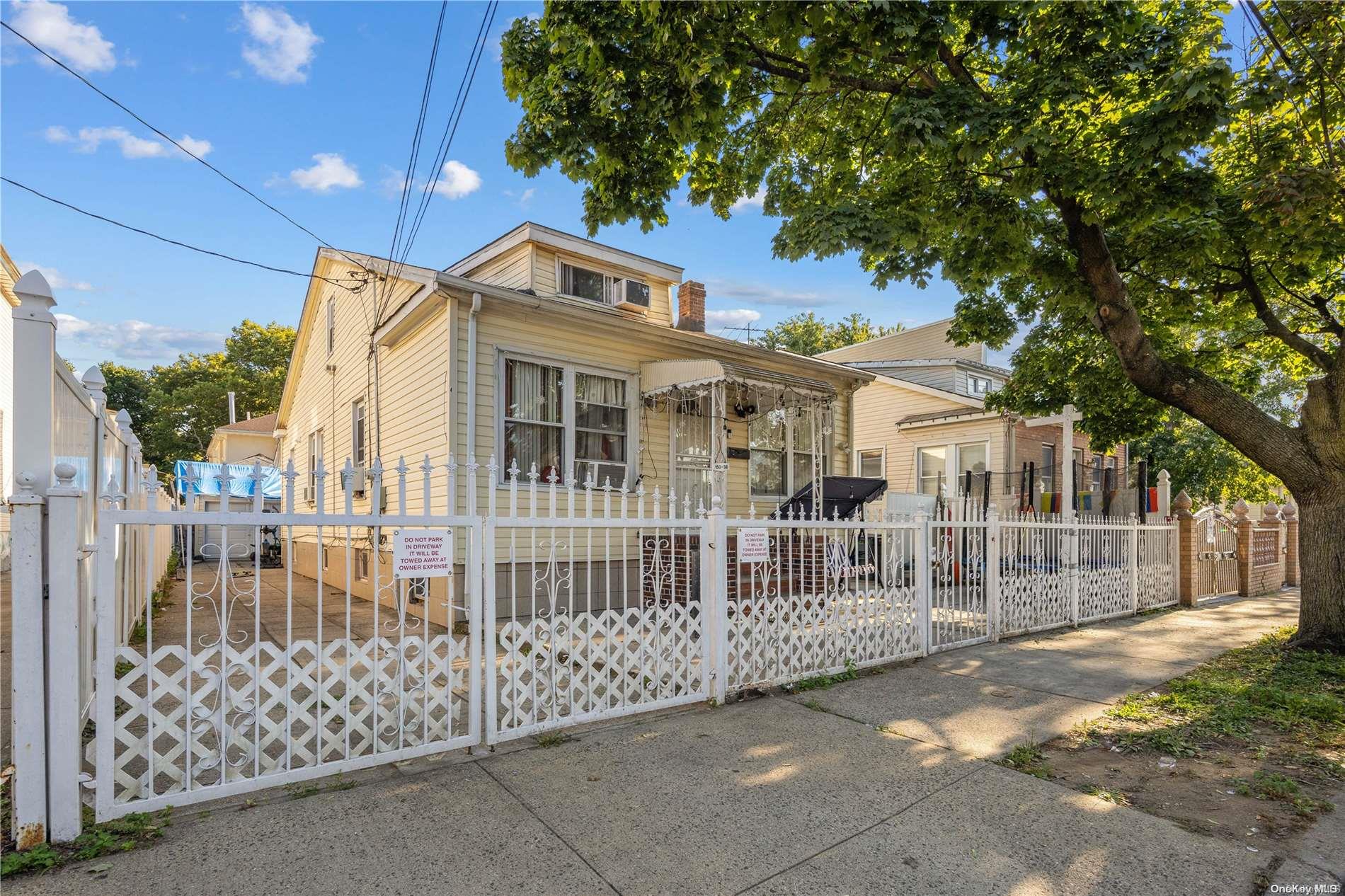 a view of a house with a small yard and wooden fence