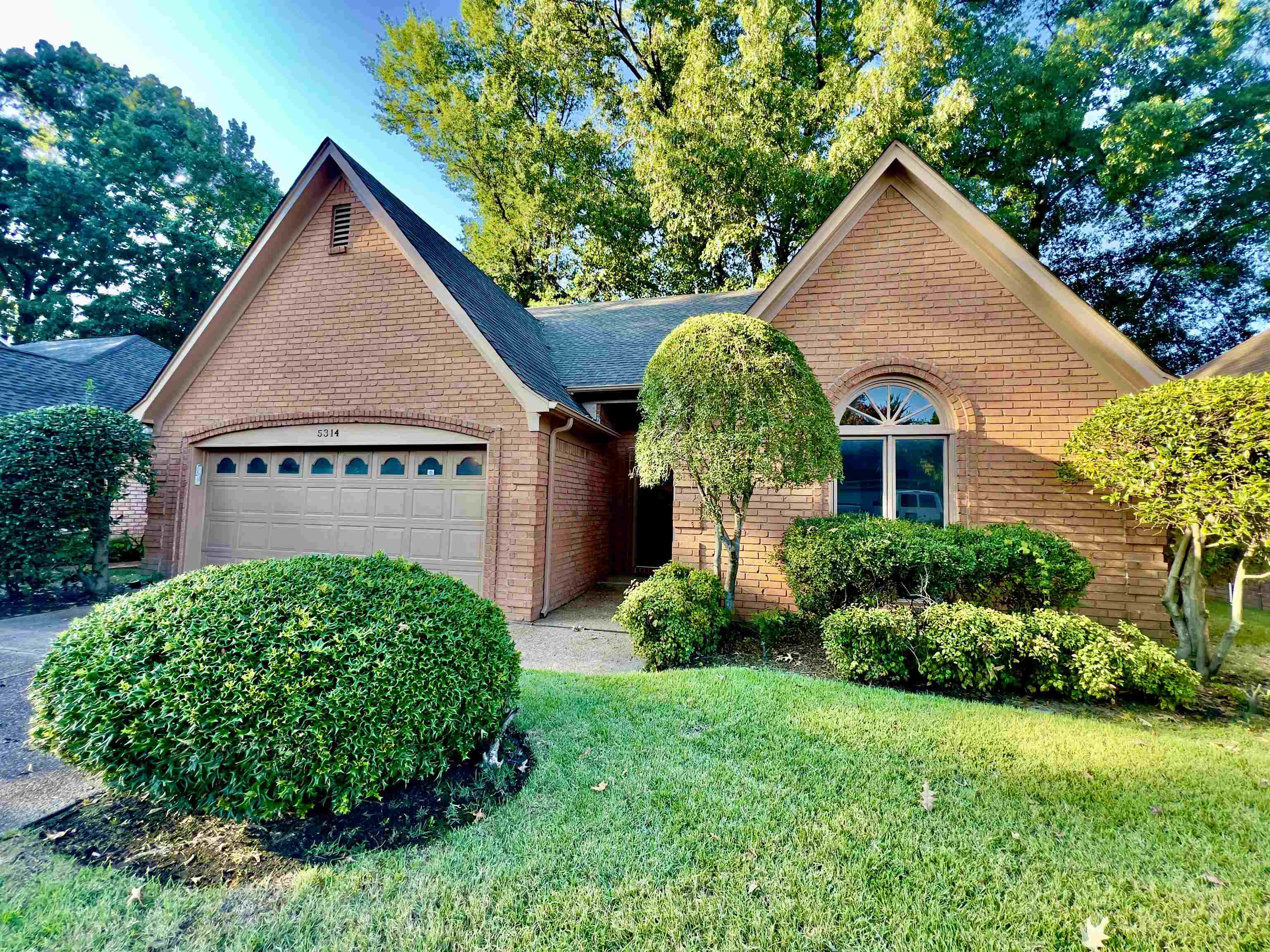 View of front of house featuring a garage and a front lawn