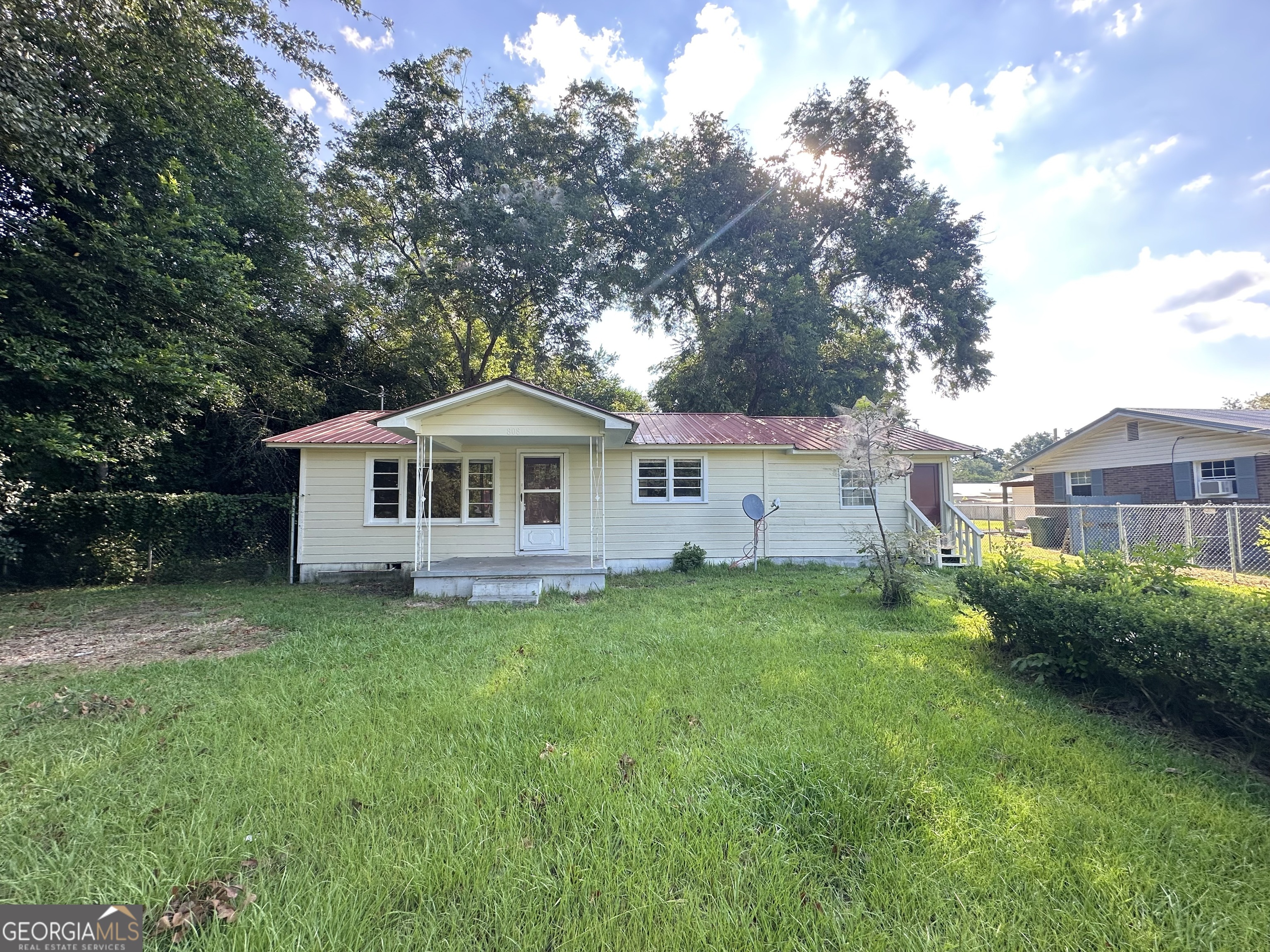 a front view of a house with a yard and trees