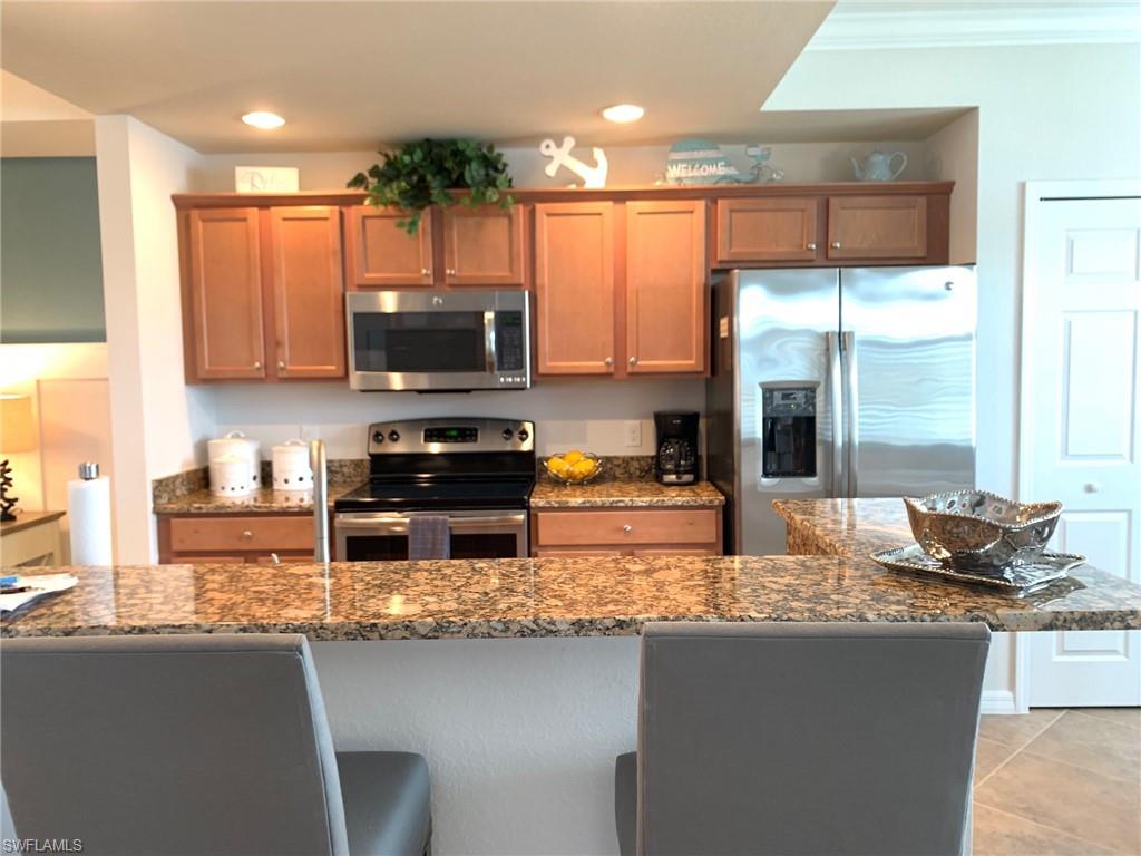 a kitchen with stainless steel appliances granite countertop a stove a sink and a microwave