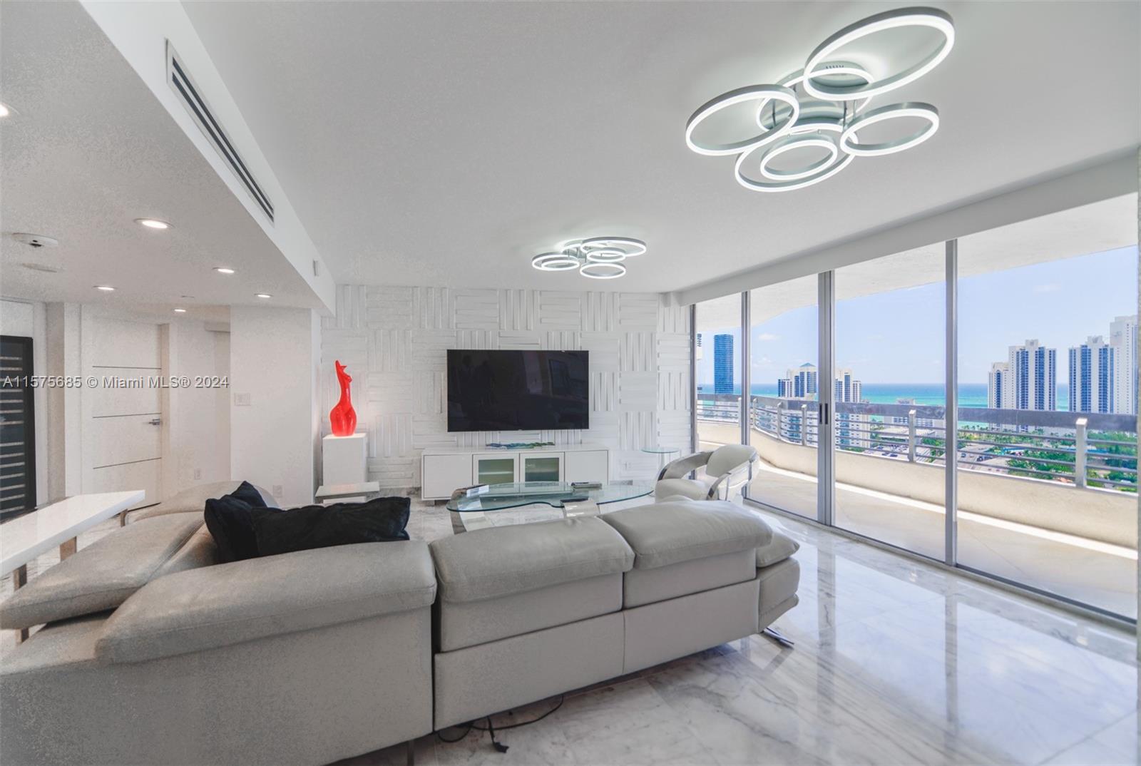 a living room with furniture a flat screen tv and a large window