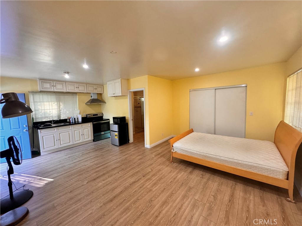 a bedroom with a bed and a view of kitchen