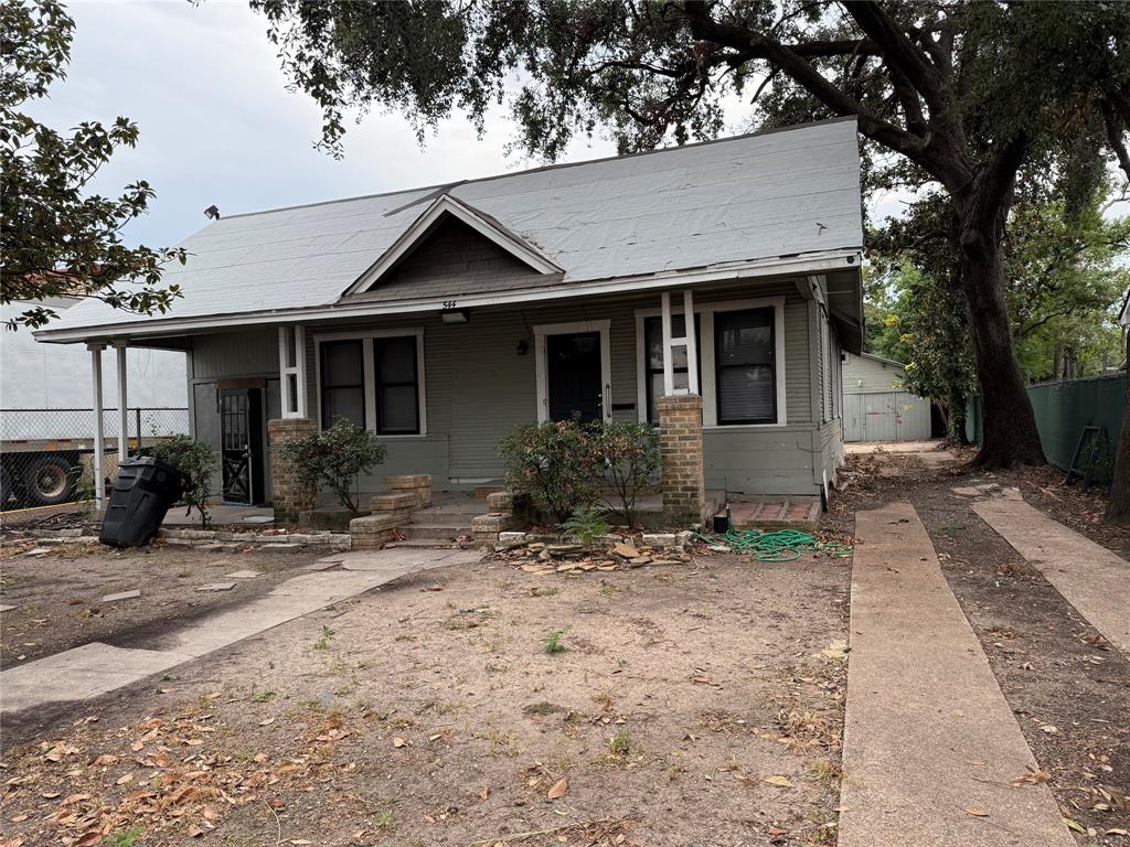 a view of a house with yard and trees in the background