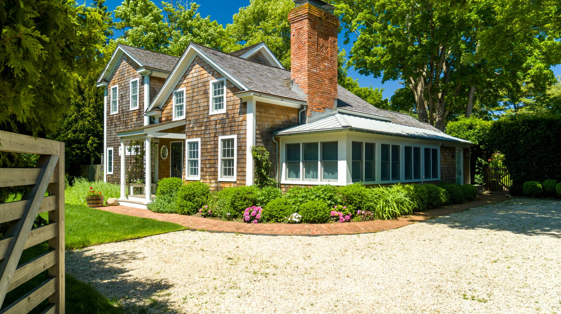 a front view of a house with a yard and potted plants