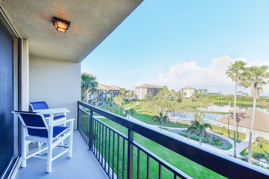 a view of a city from a balcony with dining table & chairs