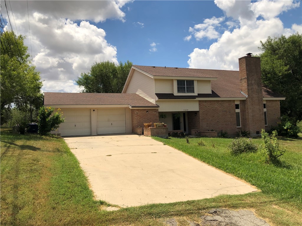 a front view of a house with a garden and yard