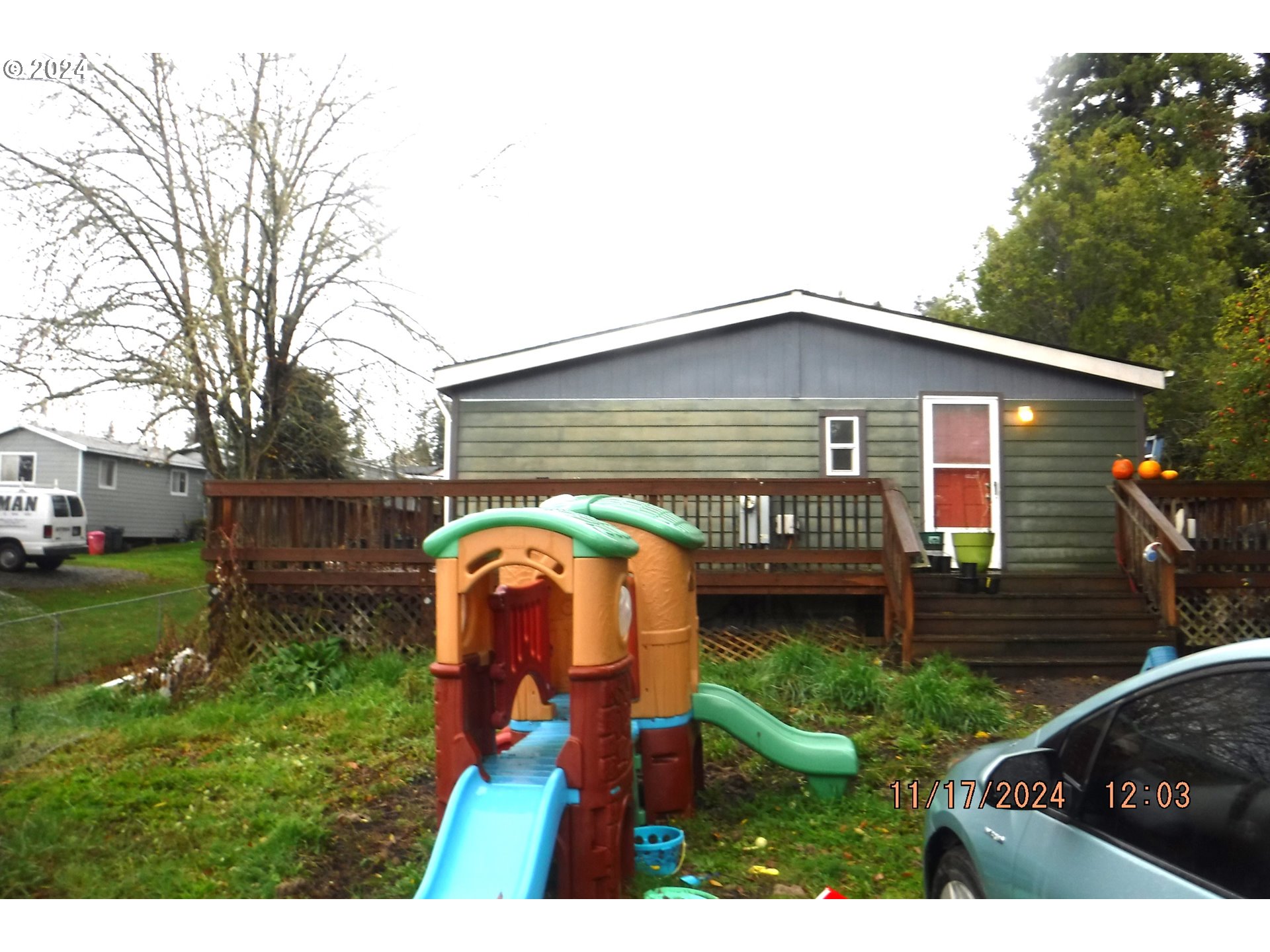 a view of backyard with wooden fence and large trees