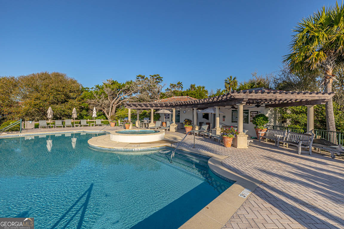 swimming pool view with a seating space and a garden