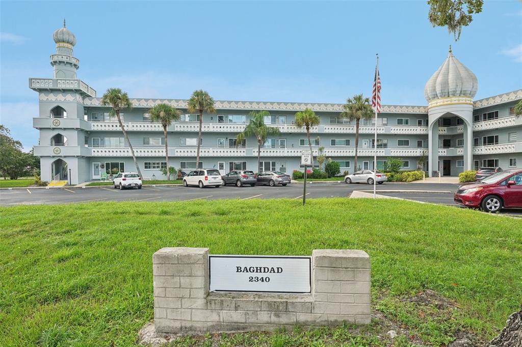 a view of a big building with big yard and large trees