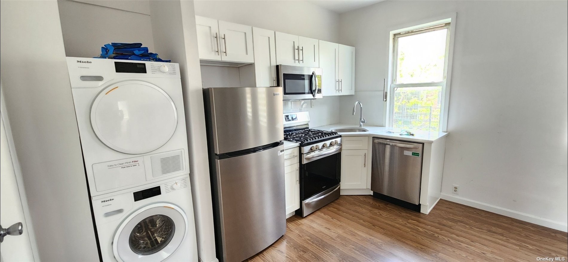 a kitchen with stainless steel appliances a stove a washer and dryer