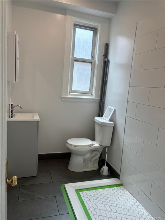 Bathroom with vanity, toilet, and tile patterned floors