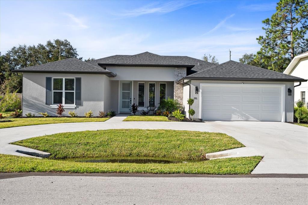 a front view of a house with a yard and garage