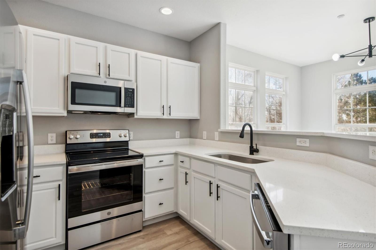 a kitchen with cabinets stainless steel appliances a sink and a window