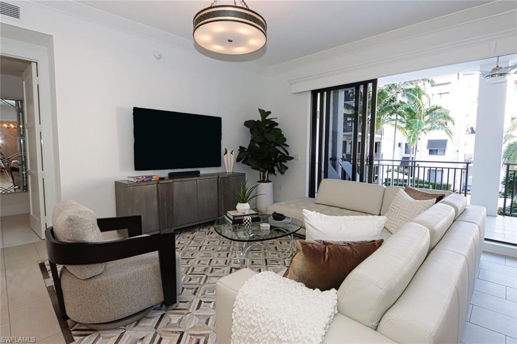 Tiled living room with a healthy amount of sunlight and ornamental molding