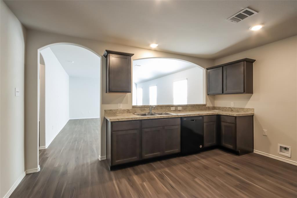 a large kitchen with granite countertop a stove and cabinets