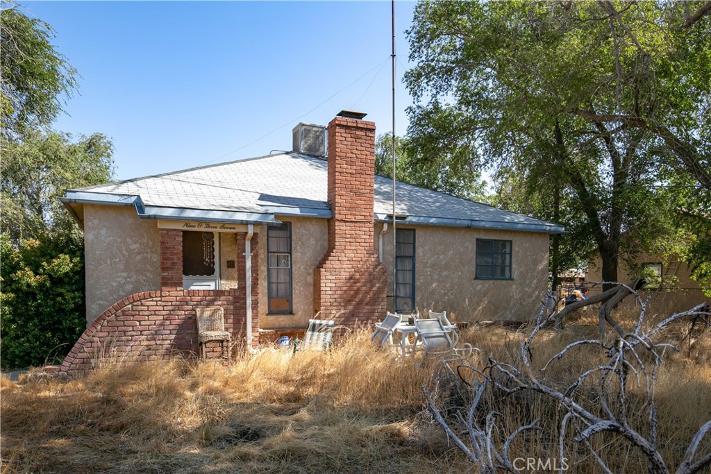 a front view of house with yard and trees around