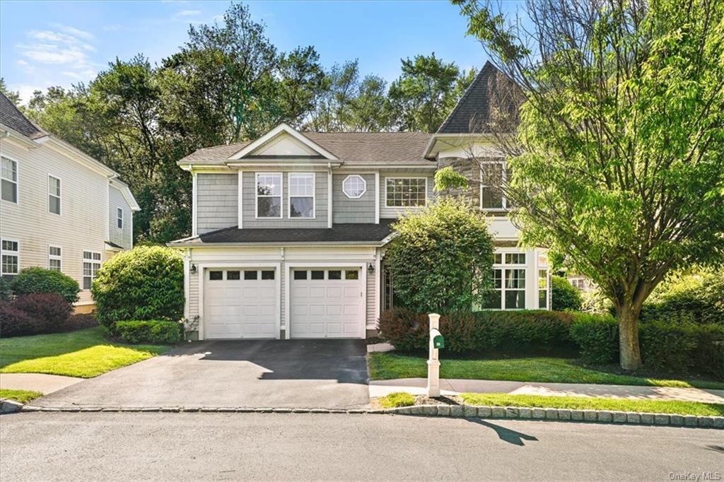 View of front of property with a garage and a front lawn